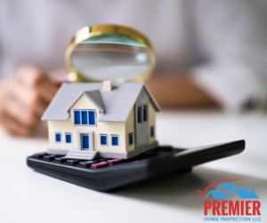 A person holding a magnifying glass over a lifelike house model placed on a calculator, symbolizing a thorough home inspection is needed to accurately assess your financial investment. 