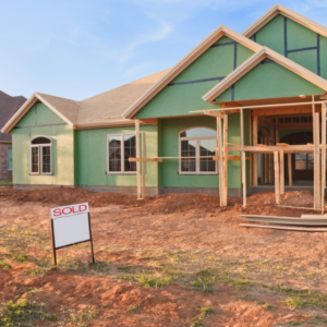 New construction home with sold sign in the front yard.